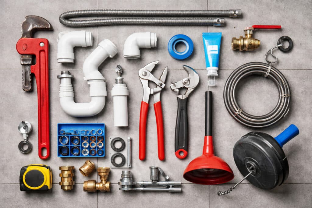 Kit indispensable du plombier avec clés à molette, pinces, siphon, raccords et déboucheur de canalisations
